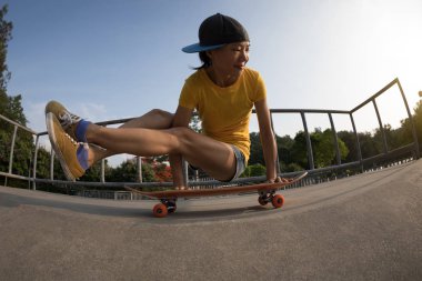 Genç kadın pratik yoga skatepark rampa, kaykay üzerinde