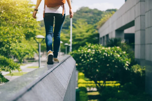 都市の都市建物壁のエッジの上を歩く若い女性 — ストック写真