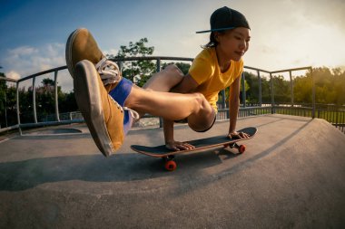 Genç kadın pratik yoga skatepark rampa, kaykay üzerinde