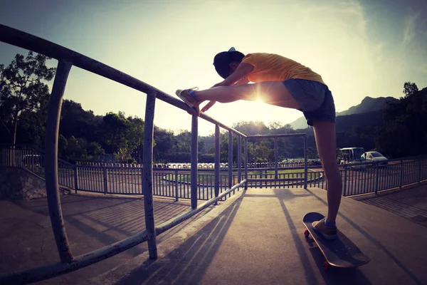 Νεαρή Γυναίκα Skateboarder Τέντωμα Ποδιών — Φωτογραφία Αρχείου