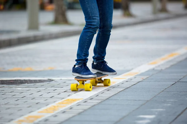 Female legs skateboarding on ctiy street