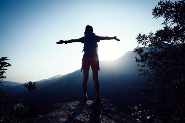 başarılı kadın uzun yürüyüşe çıkan kimse dağın tepesinde gündoğumu sırasında ayakta outstreched silah ile