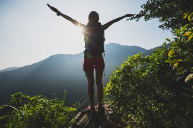 başarılı kadın uzun yürüyüşe çıkan kimse dağın tepesinde gündoğumu sırasında ayakta outstreched silah ile
