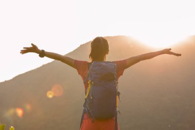 Başarılı bir yürüyüşçü yaz gündoğumu dağının zirvesinde yürüyüş yapıyor.