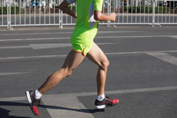 在城市道路上运行的马拉松跑步者腿 — 图库照片