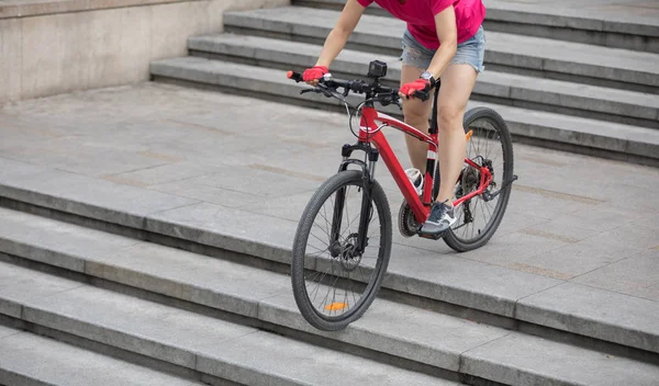 Woman freerider riding down city stairs. Sports extreme and active lifestyle