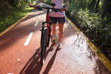 Genç bisiklet ile yolda yürüyen atış kırpılmış