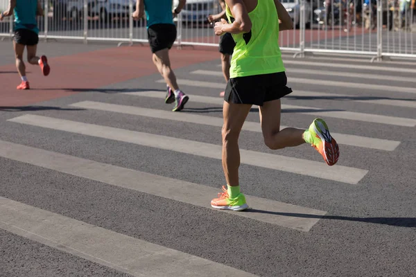 在城市道路上运行的马拉松跑步者腿 — 图库照片