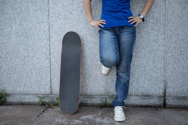 Μία Skateboarder Ακουμπά Στο Μαρμάρινο Τοίχο Στην Πόλη — Φωτογραφία Αρχείου