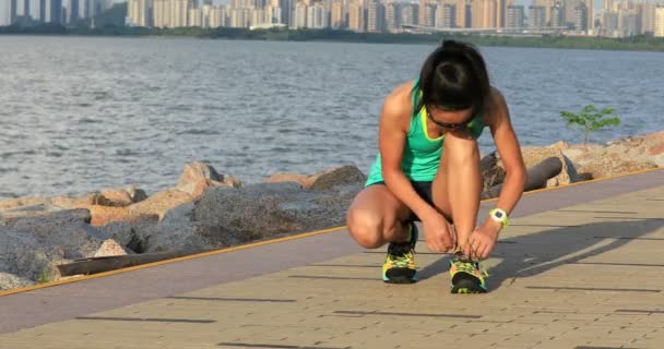 在海边慢跑前绑鞋带的运动员女孩 — 图库视频影像