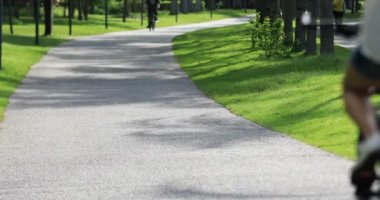 Kadın uzanmış kolları olan güneşli park izinde bir bisiklet sürme 