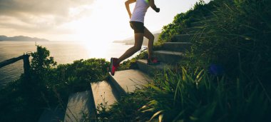 Kararlı kadın sahil dağ merdivenlerde koşma