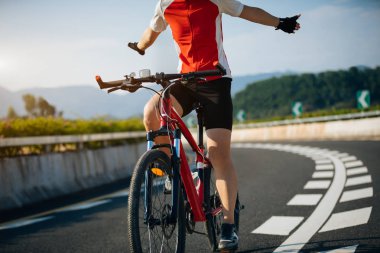 Female cyclist rides a racing bike on road clipart