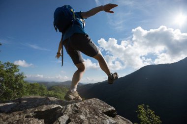 başarılı kadın uçurumun kenarına kadar dağın tepesinde yürüyen uzun yürüyüşe çıkan kimse