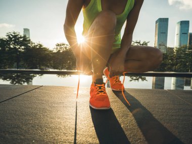 Fitness kadın runner şehir üzerinde çalıştırmadan önce bağcık bağlama
