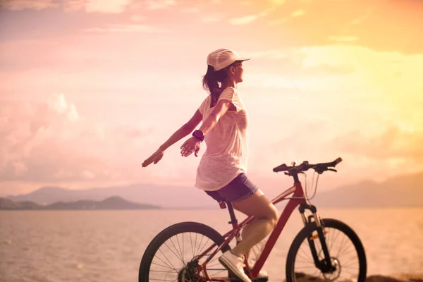 Young Woman Riding Bike Sunny Seaside Arms Outstretched — Stock Photo, Image