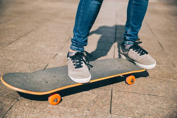 Skateboarder legs riding skateboard on city street