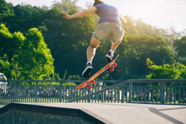 Kaykaycı skatepark içinde güneşli gün atlama