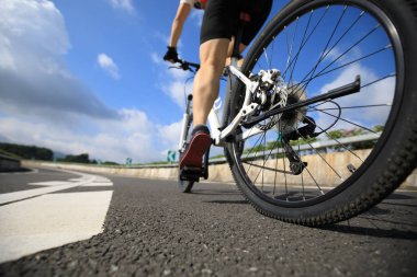 Genç kadın bisikletçi dağ bisiklet sürme karayolu üzerinde