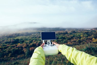 Eller sonbahar ormandaki uçan dronun uzaktan kumanda ile