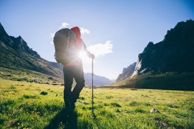 Sırt çantalı bir kadın yüksek rakım dağlarında yürüyüş yapıyor.  