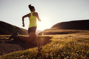 Gün batımı otlak üzerinde çalışan genç fitness kadın iz runner