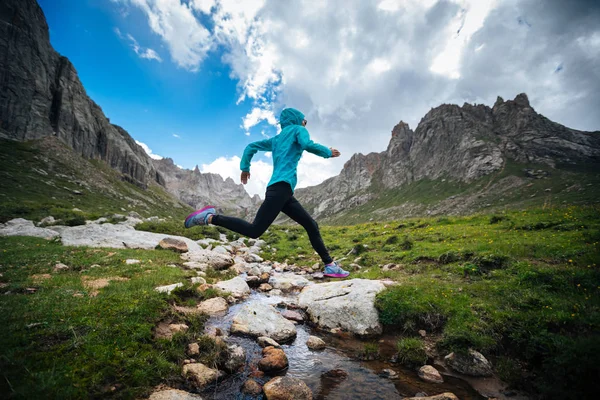 Kadın iz runner samll Nehri üzerinde güzel Dağları üzerinde atlama