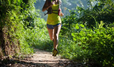 Tropikal orman iz üzerinde çalışan genç kadın iz runner