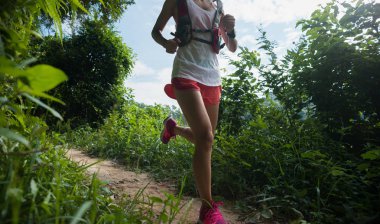 Tropikal orman iz üzerinde çalışan genç kadın iz runner