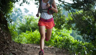 Tropikal orman iz üzerinde çalışan genç kadın iz runner