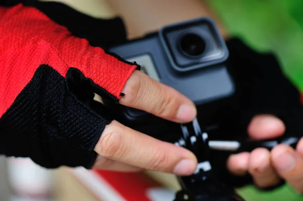 Hands mounting action camera on mountain bike