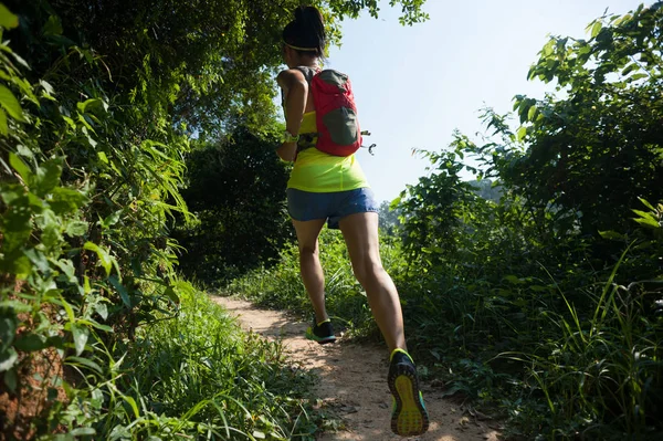 年轻的健身女工跑在阳光明媚的森林 — 图库照片
