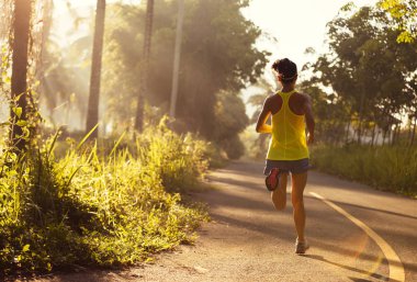 Tropikal orman iz üzerinde çalışan genç kadın iz runner