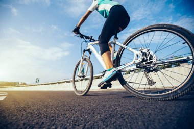 Genç kadın bisikletçi dağ bisiklet sürme karayolu üzerinde