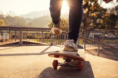 Kaykaycı skatepark rampa günbatımında kaykay