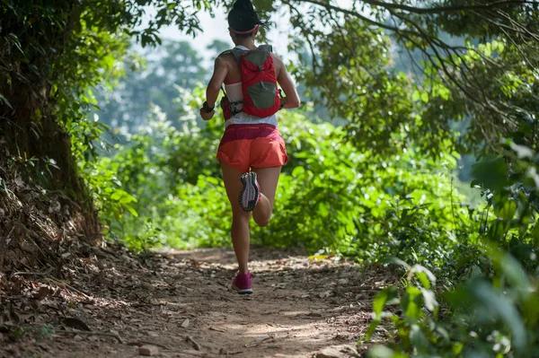 年轻女子小径赛跑者在热带森林小径上奔跑 — 图库照片