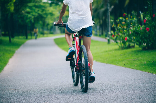 Женщина на горном велосипеде в тропическом парке