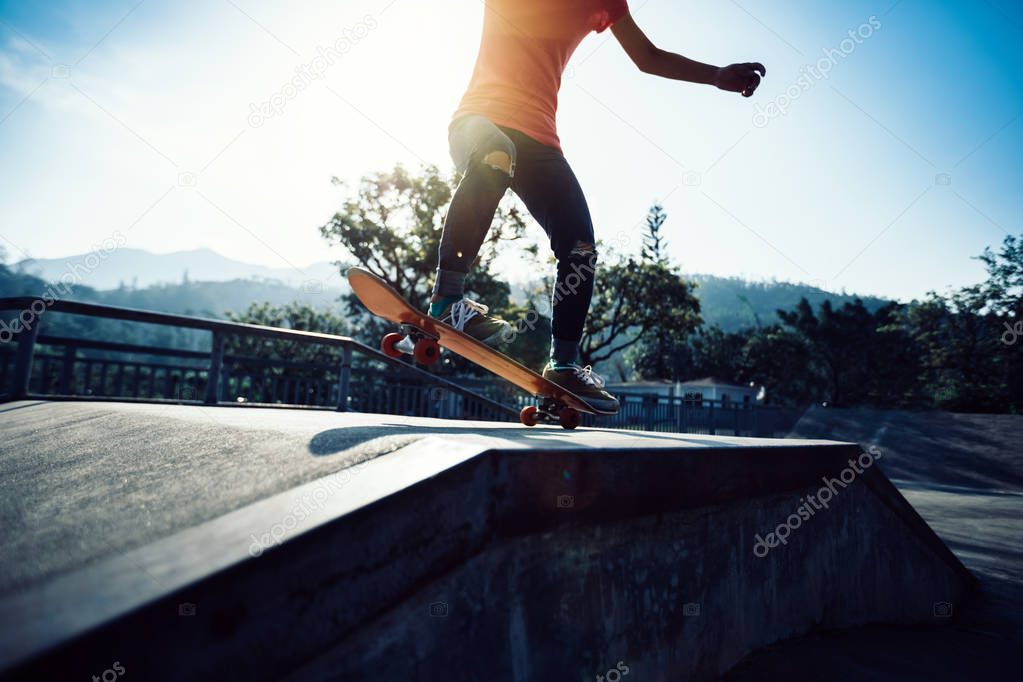 Cropped image of skateboarder skateboarding at skatepark