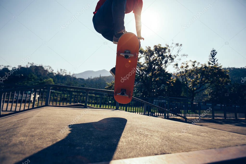 Cropped image of skateboarder skateboarding at skatepark
