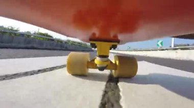 Şehir asfalt yolunda kaykay sürerken çekilmiş yakın çekim görüntüleri.