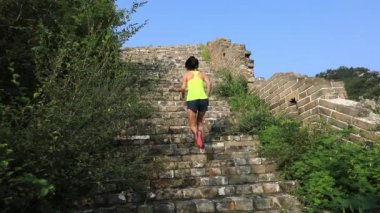 Kırsal kesimde harabelerin eski basamaklarında koşan kadın maratoncu