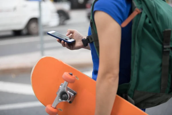 Junge Skateboarder nutzen Smartphone — Stockfoto