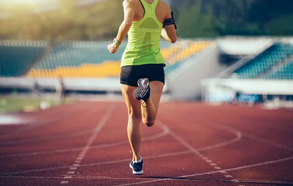 在体育场跑道上奔跑的年轻女运动员 — 图库照片