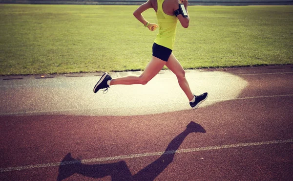 在体育场跑道上奔跑的年轻女运动员 — 图库照片