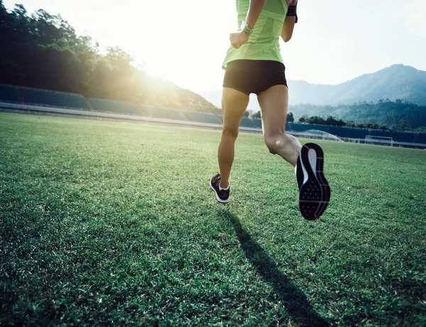 在体育场草地上跑步的健身女运动员 — 图库照片