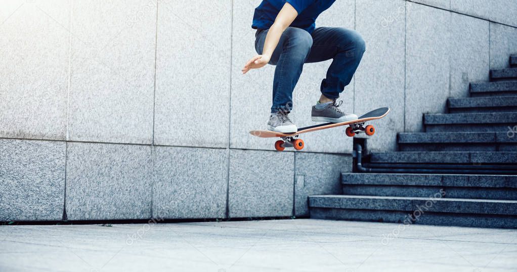 Skateboarder doing ollie at city skatepark