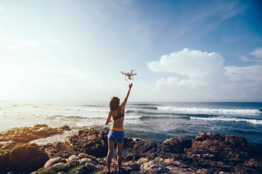 Bir dron sahil üzerinde kapalı alarak veya iniş kadın fotoğrafçı