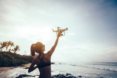 Bir dron sahil üzerinde kapalı alarak veya iniş kadın fotoğrafçı 