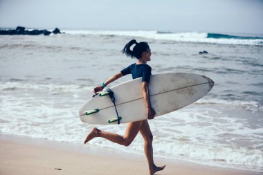 Sörfçü kadın kum plajındaki surfboard ile 