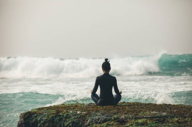 Genç kadın karşı karşıya gelen dalgalar güçlü deniz sahil uçurumun kenarında meditasyon